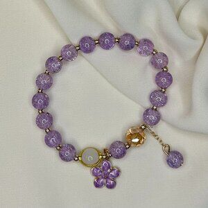 Purple beaded bracelet with a flower charm!